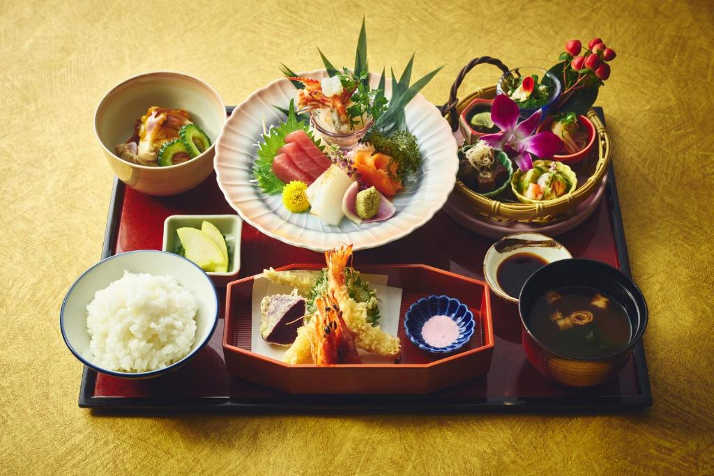 a tray with plates of food and bowls of rice at ANA InterContinental Manza Beach Resort by IHG in Onna