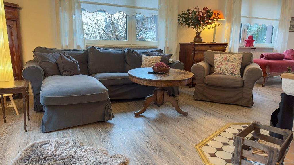 a living room with a couch and a table and chairs at Haus-Kuestenzauber-Laura-und-Sarah in Cuxhaven