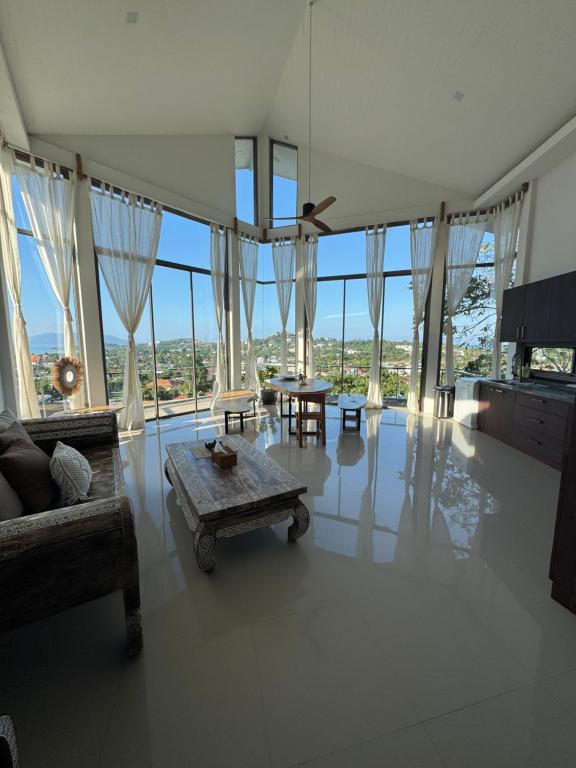 - un salon avec un canapé, une table et des fenêtres dans l'établissement Villa Chamnan, à Choeng Mon Beach