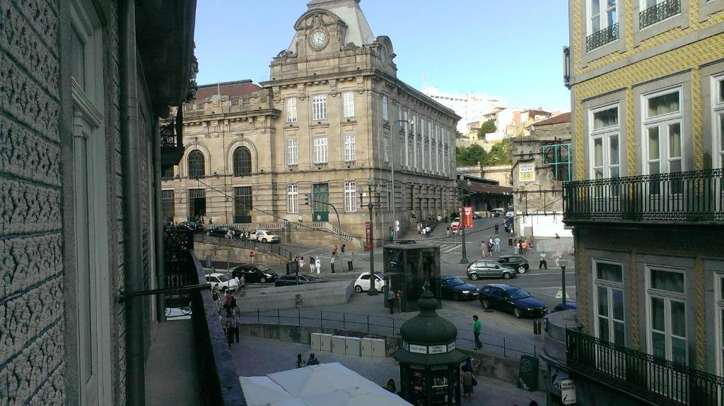 uma vista para uma rua da cidade com uma torre do relógio em Trindade Apartment em Porto