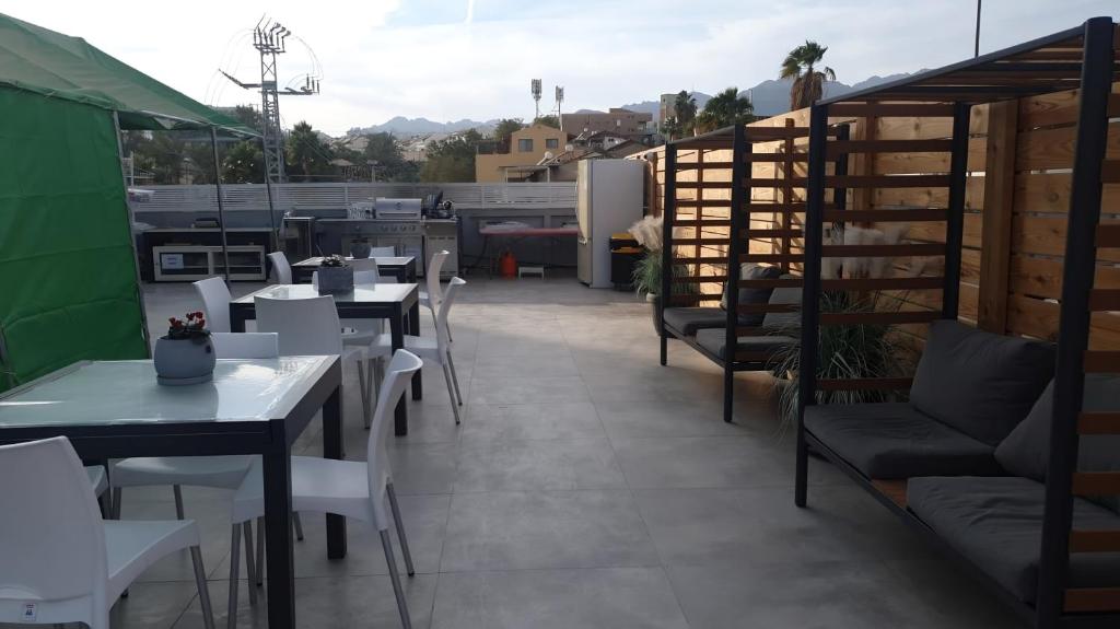 a patio with tables and chairs on a roof at Sun Sea Center in Eilat