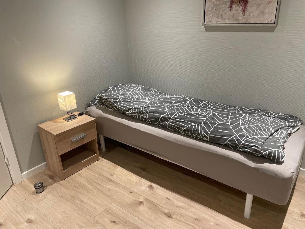 un letto con piumone bianco e nero e un tavolino di Rømersgaard a Padborg
