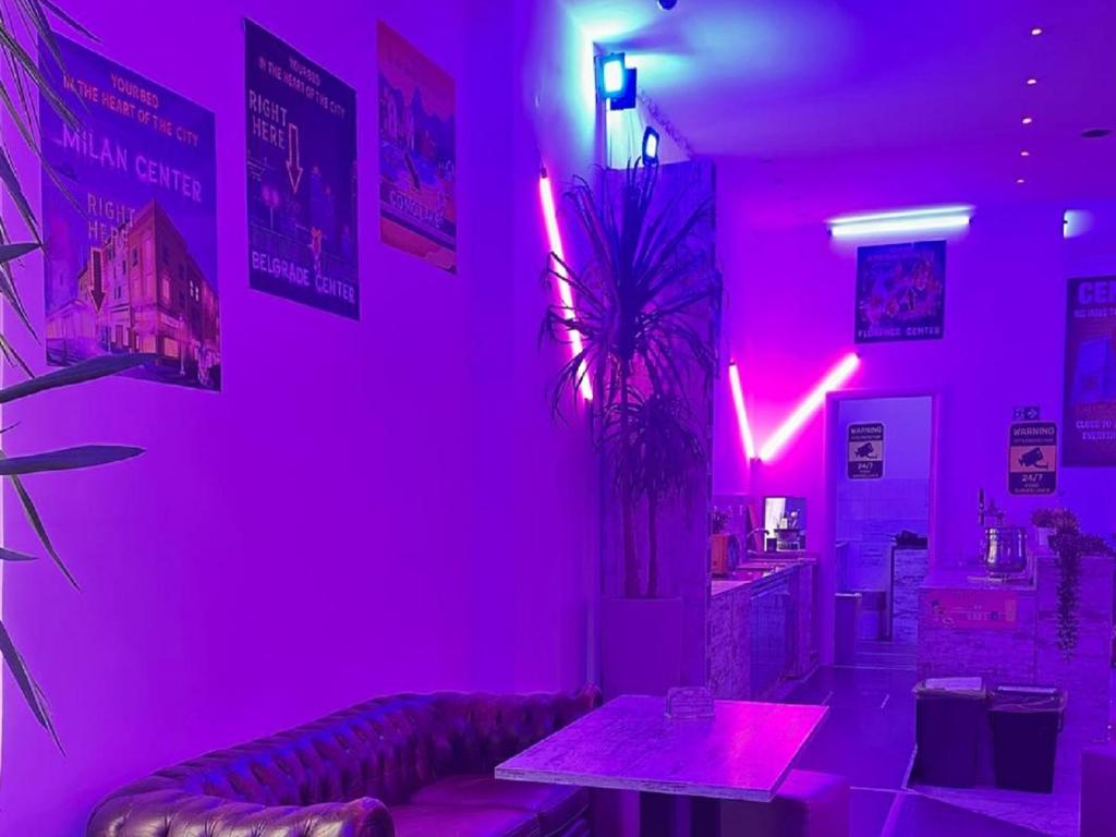Habitación rosa con sofá y mesa. en NEW GENERATION HOSTEL Navigli Milano, en Milán