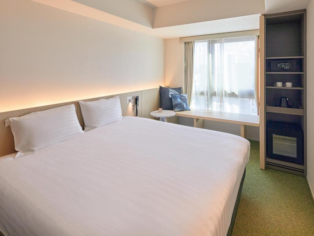 Postel nebo postele na pokoji v ubytování Dorsett by Agora Osaka Sakai
