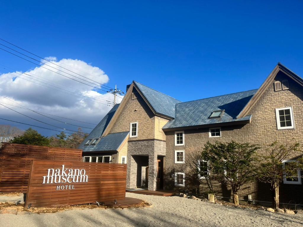 a house with a wooden fence in front of it at nakano museum HOTEL in Hokuto