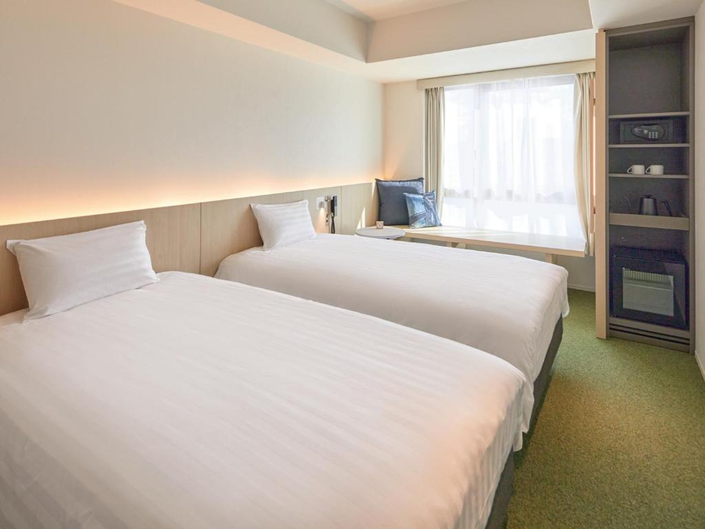 Postel nebo postele na pokoji v ubytování Dorsett by Agora Osaka Sakai