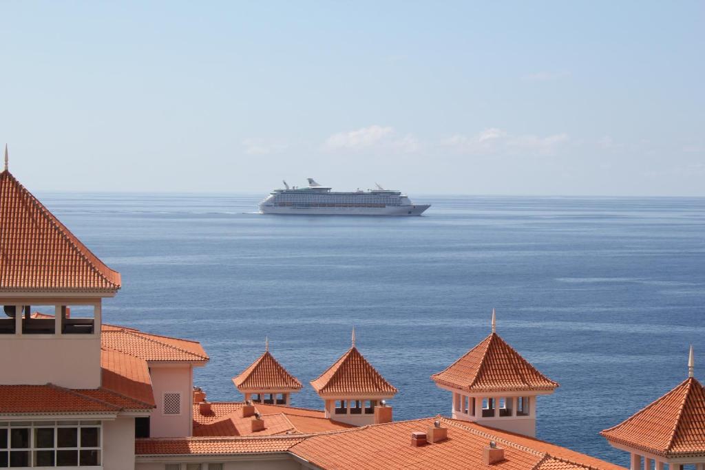 a cruise ship in the water with buildings at Penthouse Canico Mar in Caniço