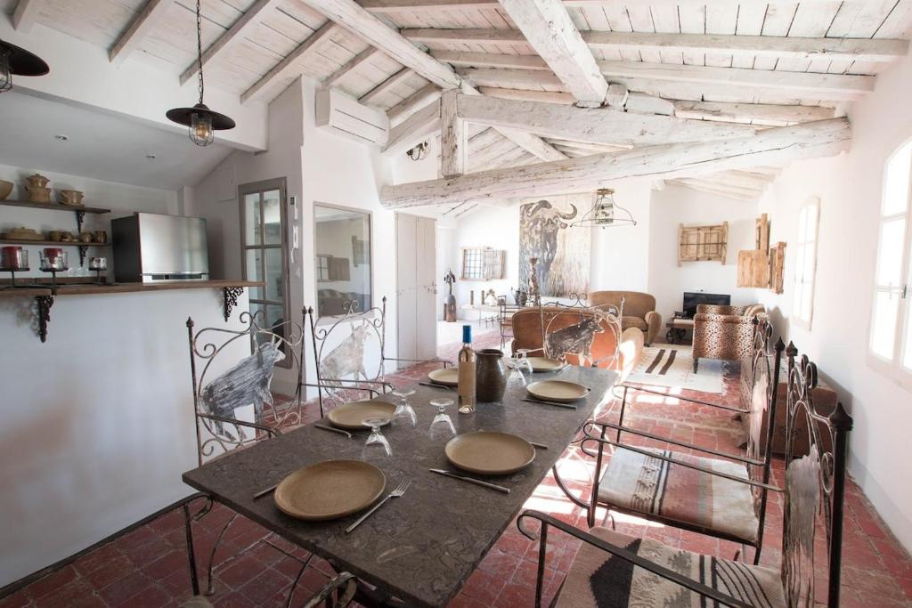 une salle à manger avec une table et des chaises dans une pièce dans l'établissement Loft Toro - Premium, Clim et Terrasse, à Arles