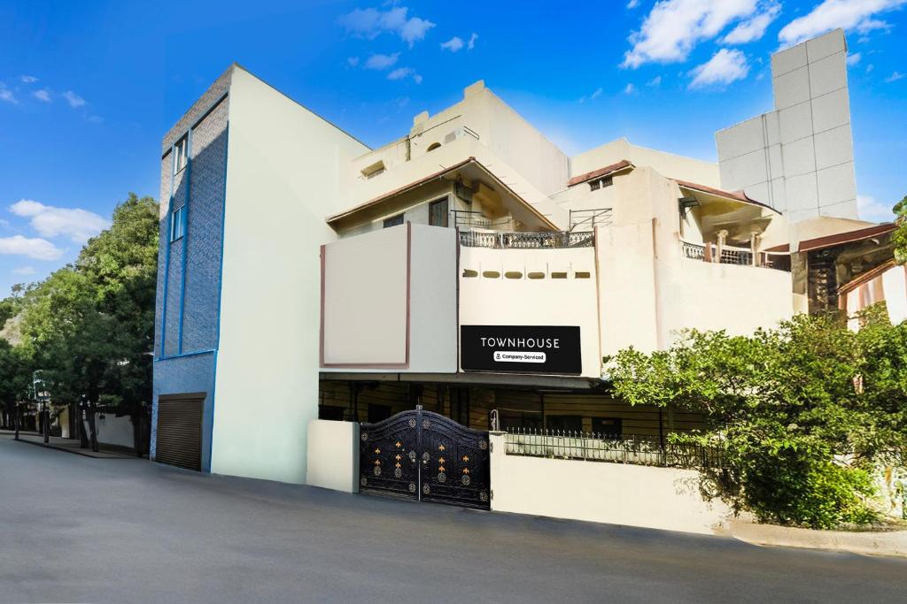 un bâtiment blanc avec un panneau dessus dans l'établissement Super Townhouse Townvilla Guesthouse, à Ameerpet