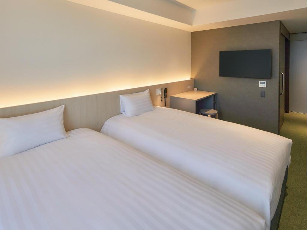 Postel nebo postele na pokoji v ubytování Dorsett by Agora Osaka Sakai