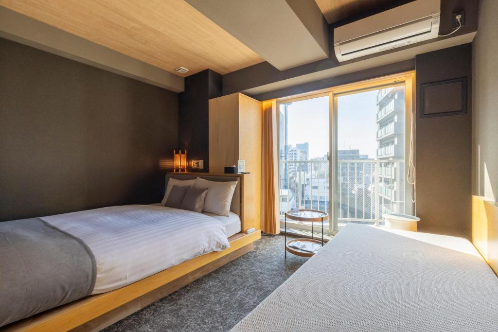 Postel nebo postele na pokoji v ubytování HOTEL TOMOS ASAKUSA