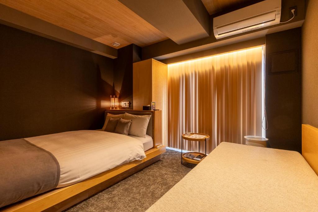 Postel nebo postele na pokoji v ubytování HOTEL TOMOS ASAKUSA