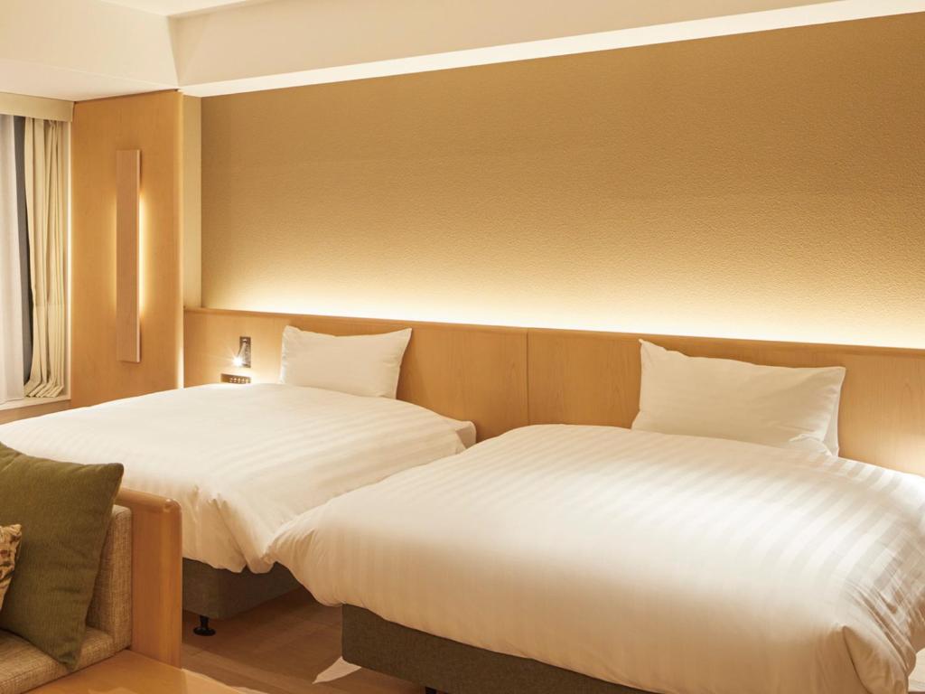 Postel nebo postele na pokoji v ubytování Dorsett by Agora Osaka Sakai