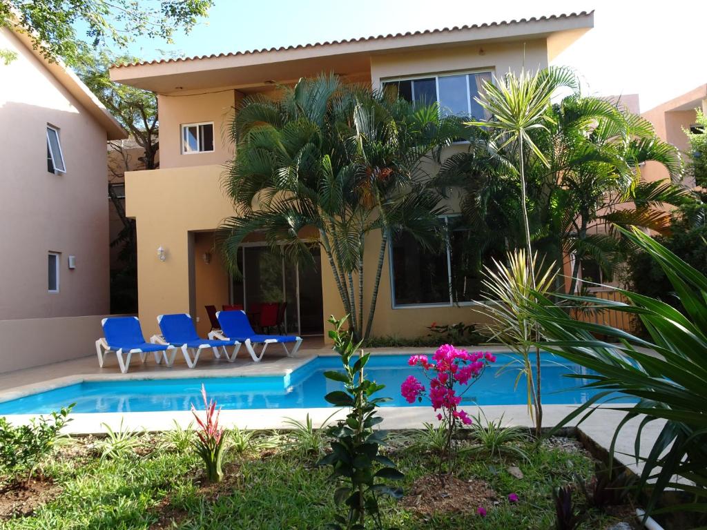 a villa with a swimming pool in front of a house at La Salamandra in Puerto Aventuras