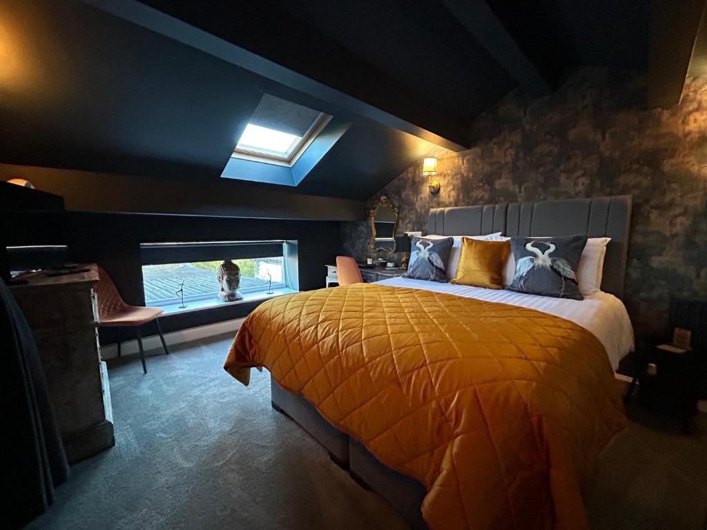 a bedroom with a large bed with a yellow blanket at Aiskew Villa Annex in Bedale