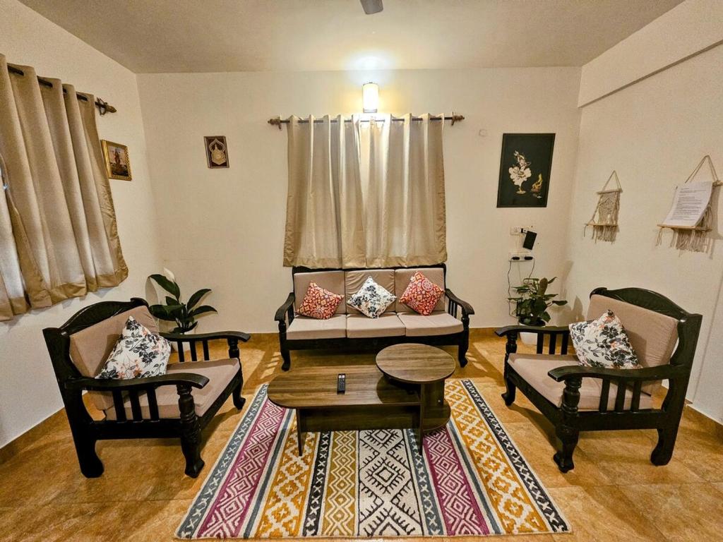 a living room with two chairs and a table at Wonder Stays 2BHK apartment, Goa in Colva