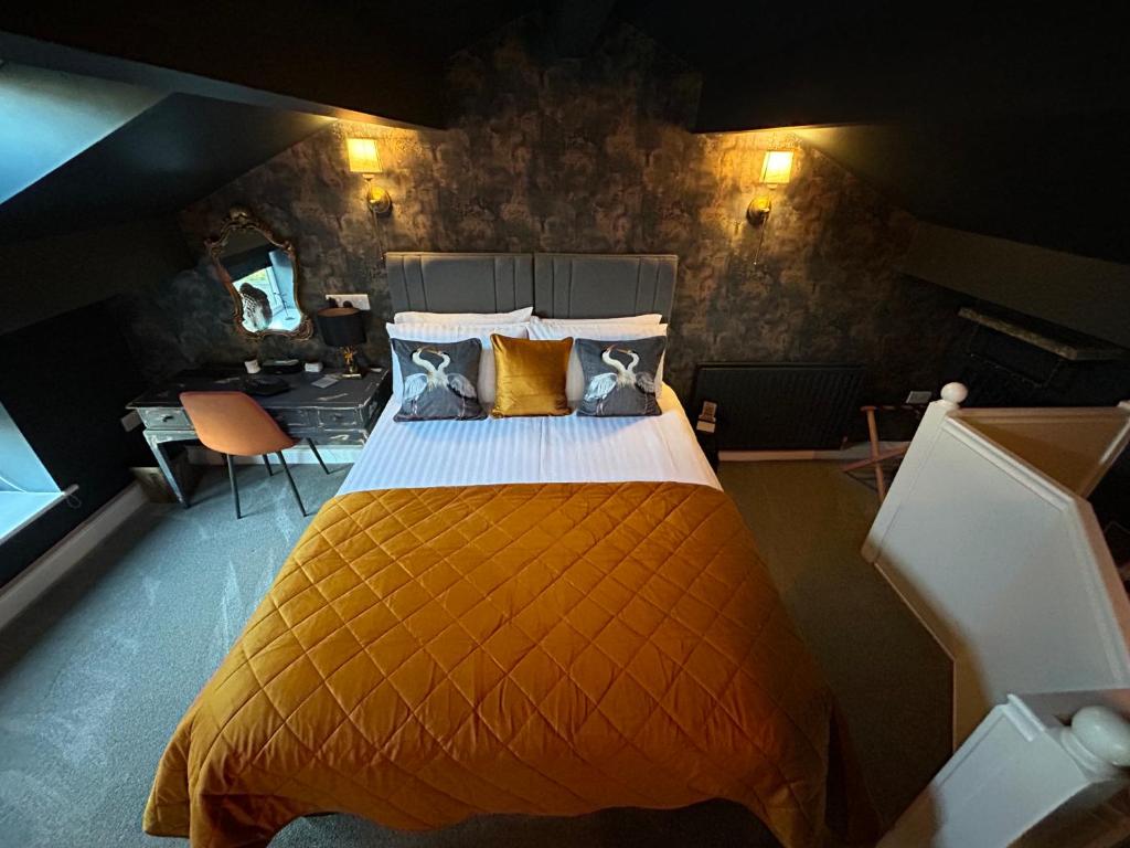 a bedroom with a large bed with an orange blanket at Aiskew Villa Annex in Bedale