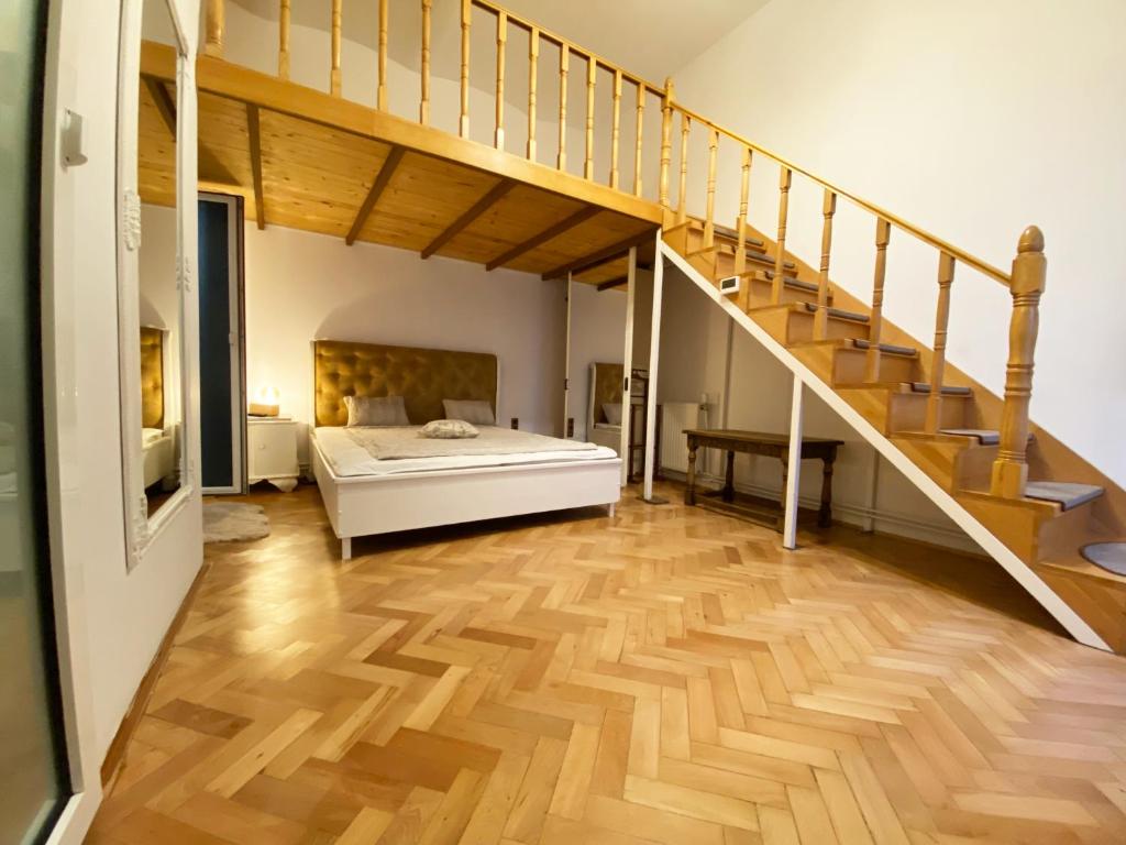 une chambre avec un lit et un escalier dans l'établissement Piața Sfatului Brassai Apartments, à Braşov