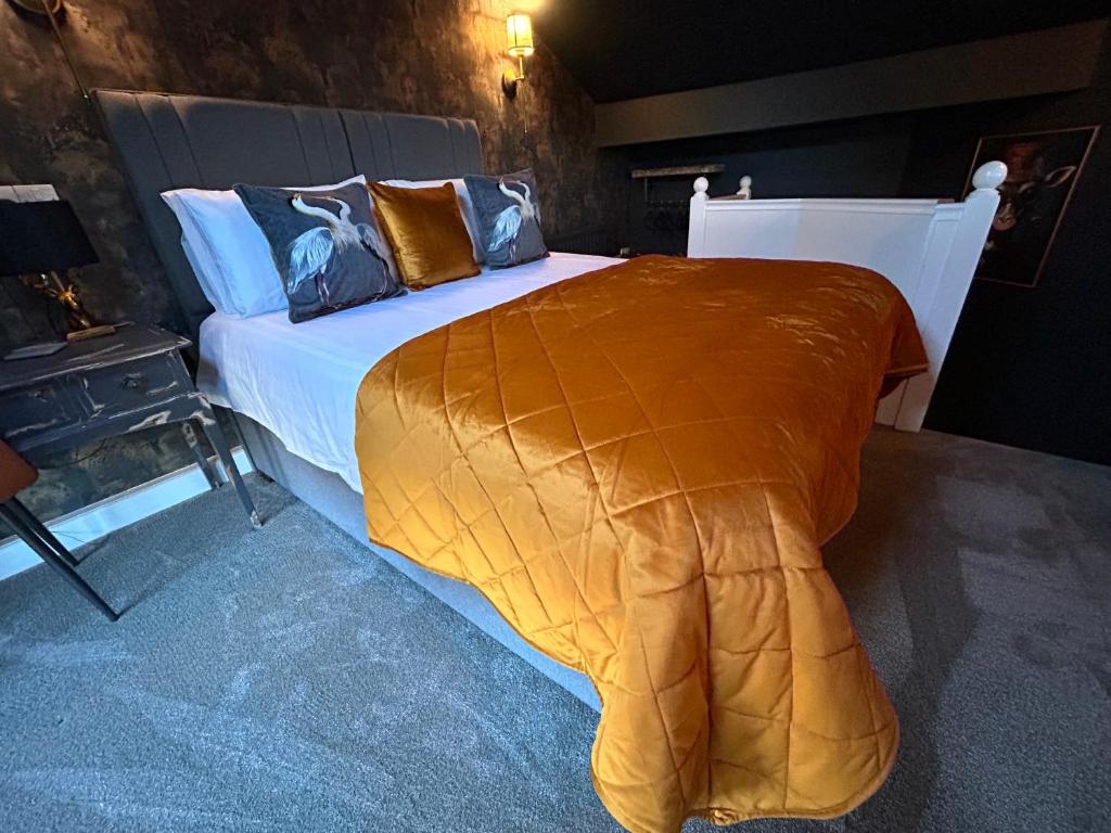 a bedroom with a large bed with a blanket at Aiskew Villa Annex in Bedale