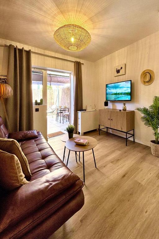 a living room with a couch and a tv at Cosy Bungalow Green Oasis in Maspalomas