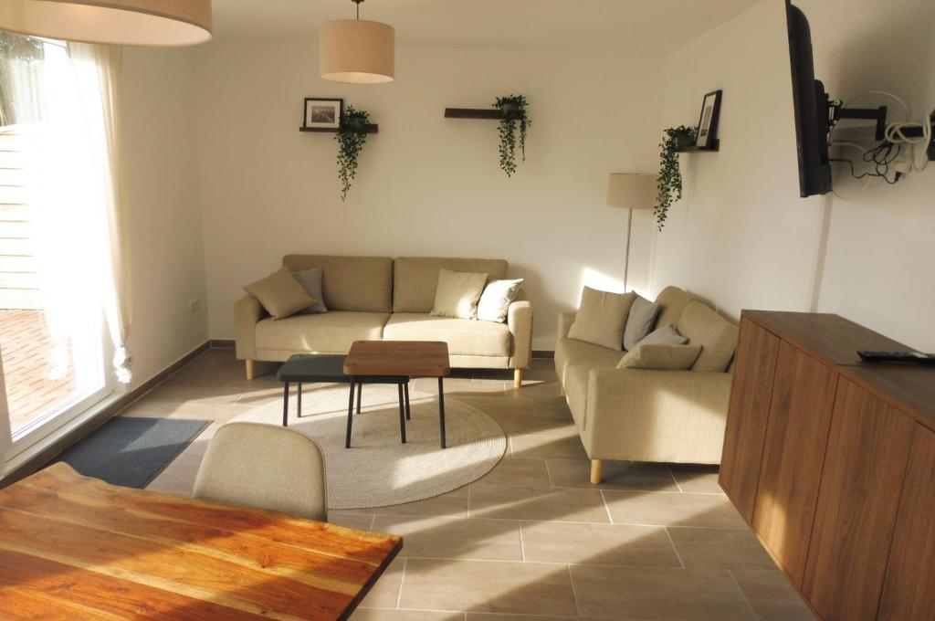 a living room with a couch and a table at Ferienhaus Marienhafe in Marienhafe
