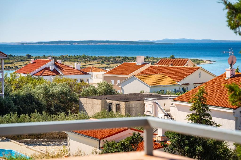 a view from the balcony of a house with orange roofs at Bady Apartments with BBQ in Novalja