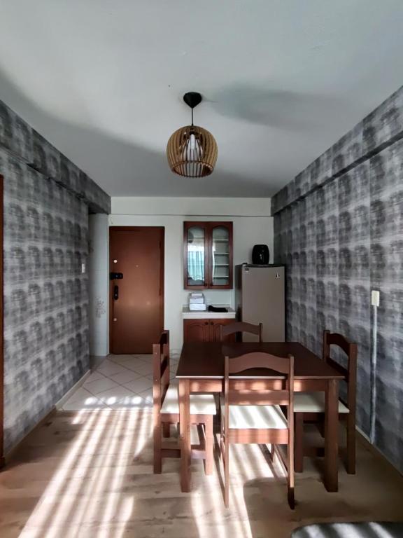 une salle à manger avec une table et un réfrigérateur dans l'établissement Apto central com estacionamento, à Poços de Caldas