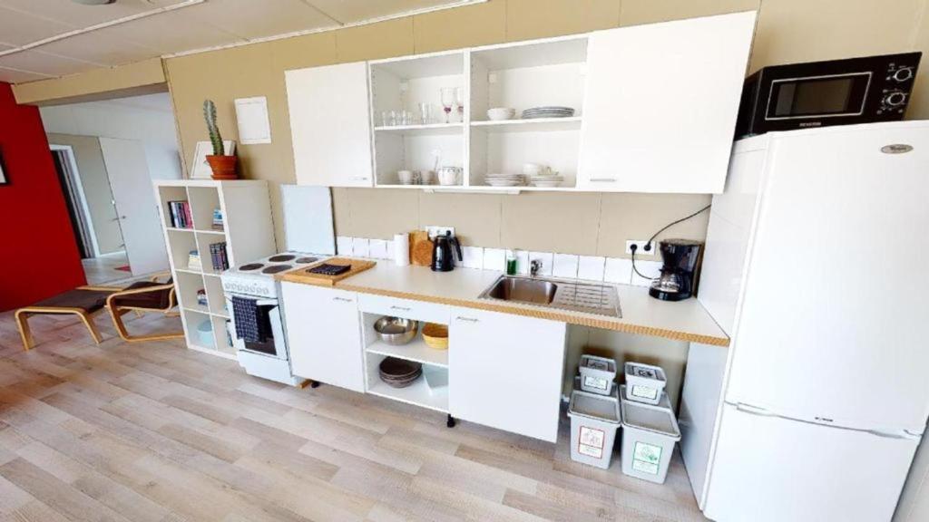 una cucina con armadietti bianchi e frigorifero bianco di Brenna - Ocean View Apartment a Hellissandur