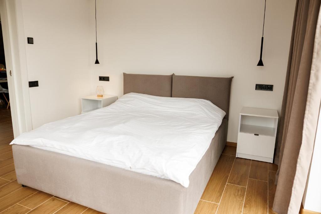 a bedroom with a white bed with a white bed frame at Лісогори in Slavske