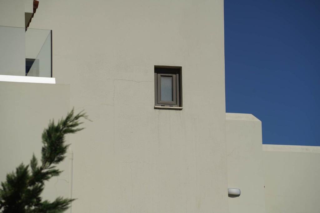 a small window on the side of a white building at Malena Hotel & Suites - Adults Only by Omilos Hotels in Amoudara Herakliou