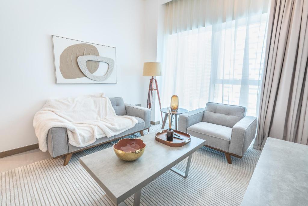a living room with a couch and a chair and a table at Aven Apartment Dubai 2BR-2209 in Urban Oasis by Missoni-Business Bay Dubai in Ghantoot