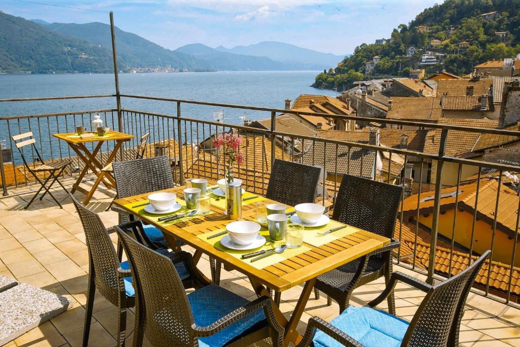 a table on a balcony with a view of the water at Casa Sofia in Cannobio