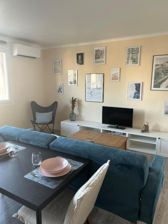 un salon avec un canapé bleu et une table dans l'établissement Le Citadin T3, à Marseille