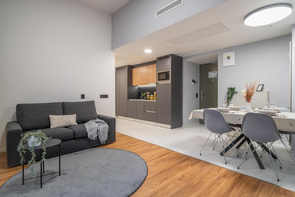a living room with a couch and a table at City Pop Prague Aparthotel in Prague