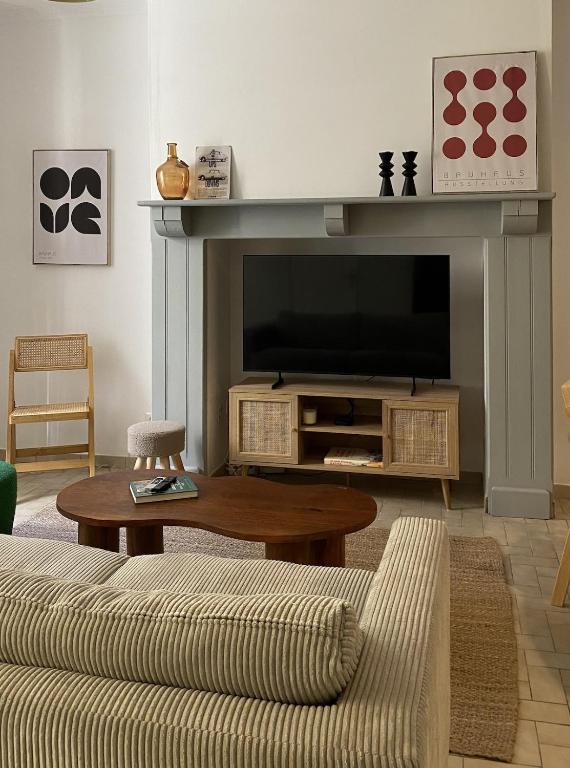 a living room with a fireplace with a television at Maison-Cœur historique-Sarlat in Sarlat-la-Canéda