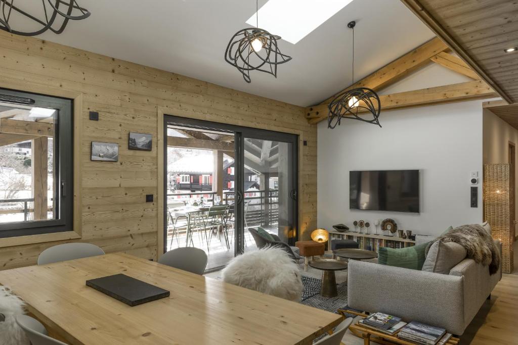 - un salon avec des murs en bois et une table dans l'établissement Nid d'Aigle - Balcon - Magnifique vue Mont Blanc, aux Houches