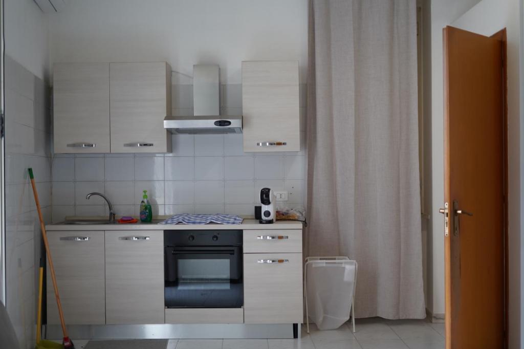 a small kitchen with white cabinets and a stove at Casa FLAVIA in Serracapriola