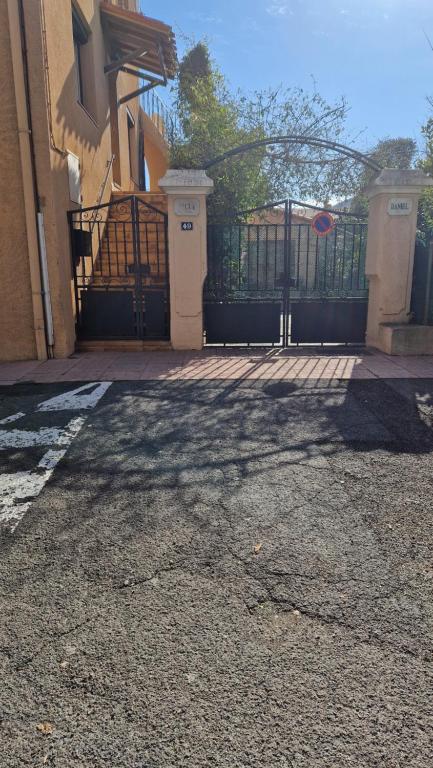 un portail en face d'une maison avec une clôture dans l'établissement Appartement au premier étage dans maison de charme avec grand jardin au RDC, à Banyuls-sur-Mer
