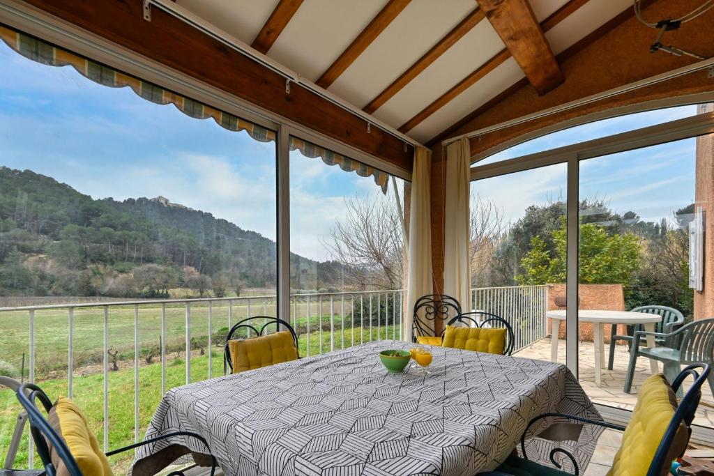 Un comedor con mesa y sillas en un patio. en L’Écrin du Brulat - Jardin et vue montagnes, en Le Castellet