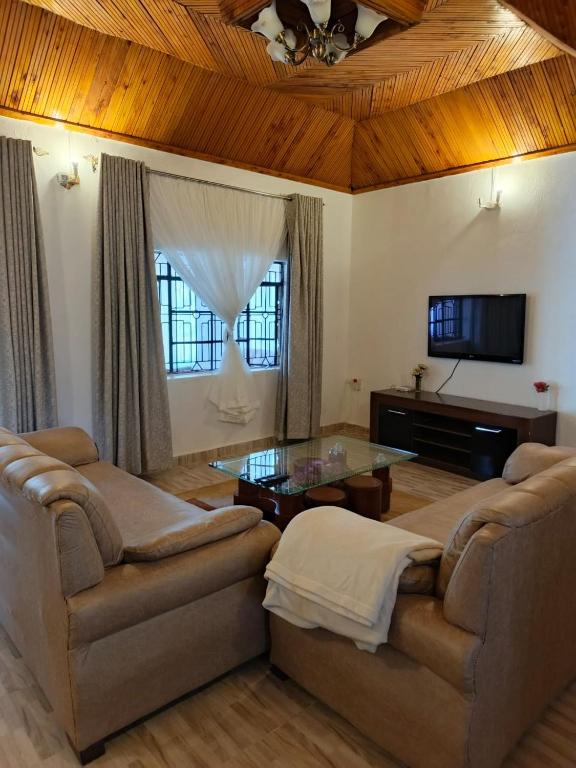 un soggiorno con due divani e un tavolo di RUWAMU Guesthouse a Naivasha