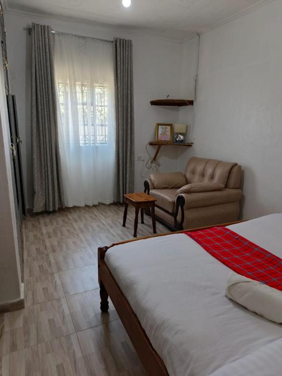 un soggiorno con letto e divano di RUWAMU Guesthouse a Naivasha