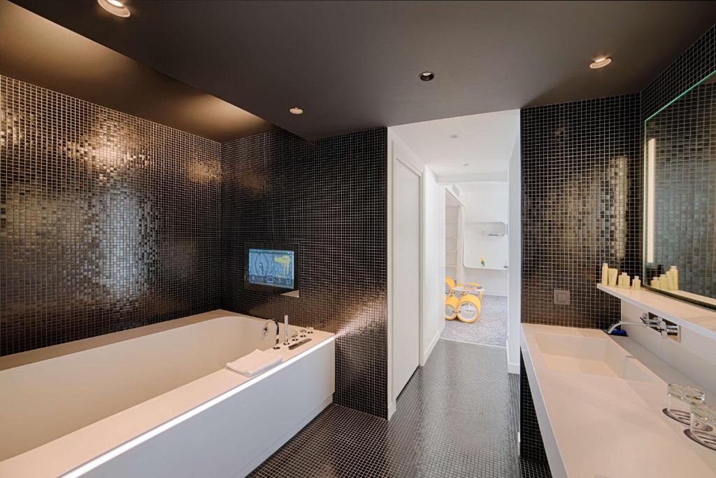 a bathroom with a large tub and a sink at nhow Marseille in Marseille