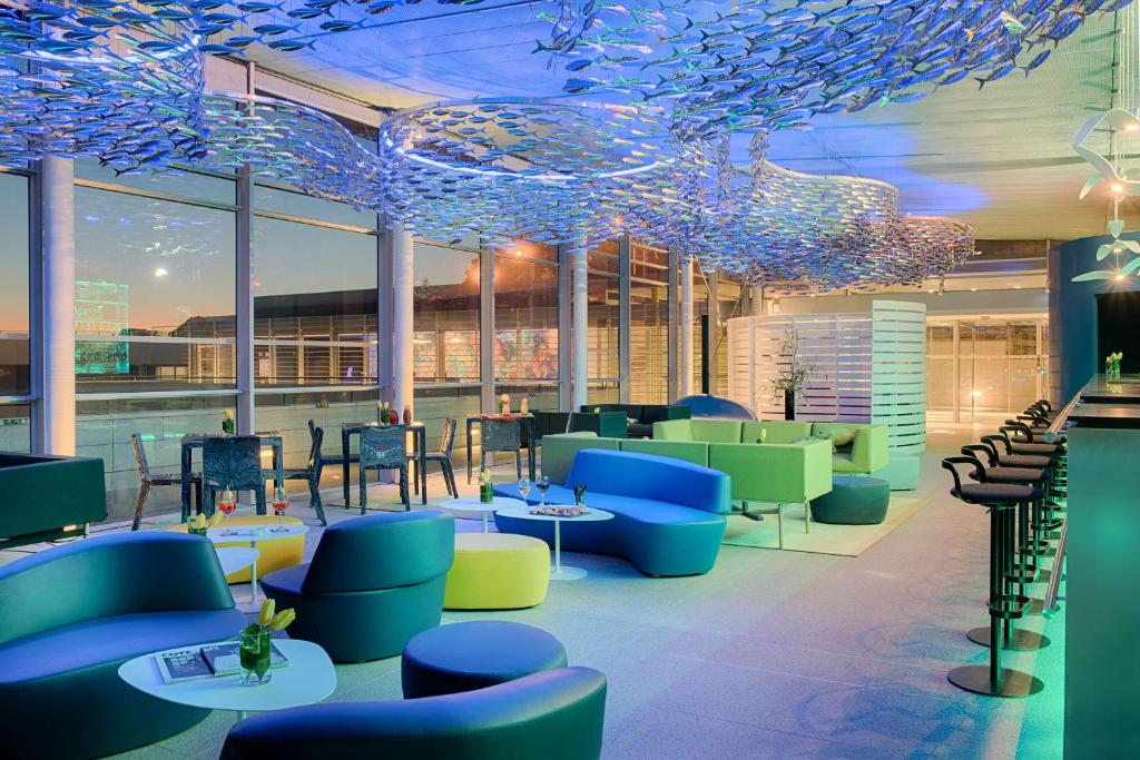 a restaurant with blue and green chairs and tables at nhow Marseille in Marseille
