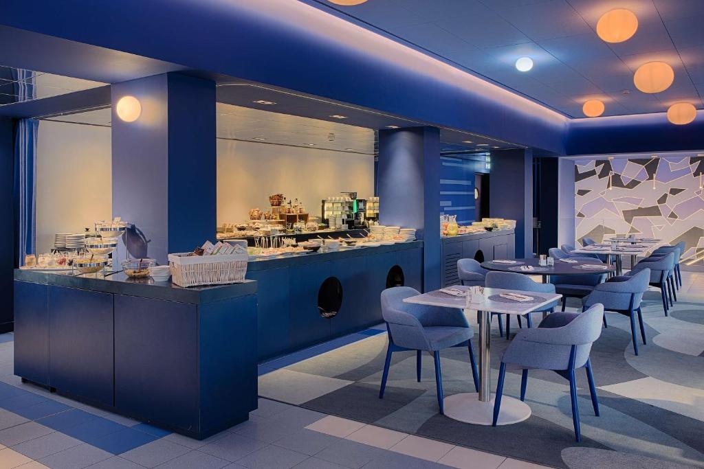 a restaurant with blue walls and tables and chairs at nhow Marseille in Marseille