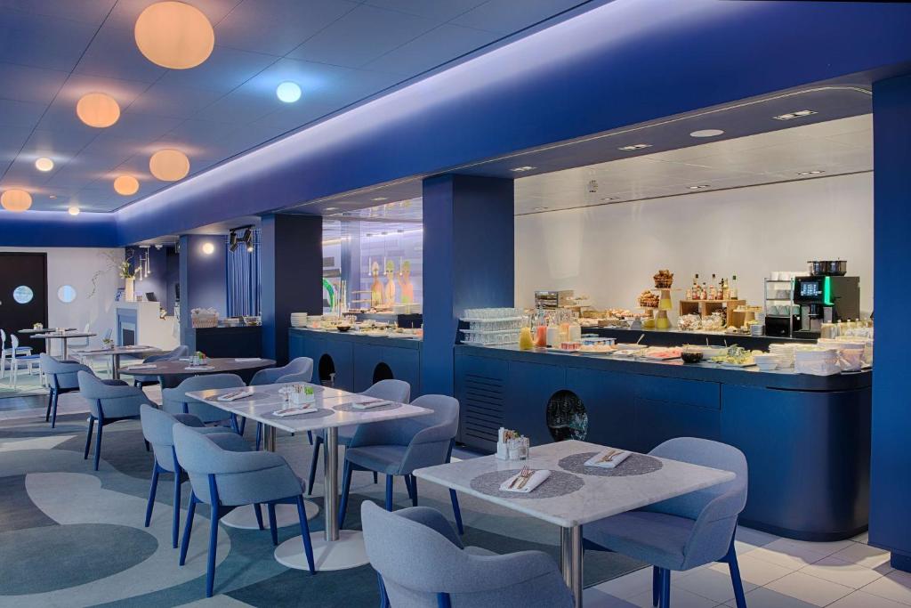 a restaurant with tables and chairs and a counter at nhow Marseille in Marseille
