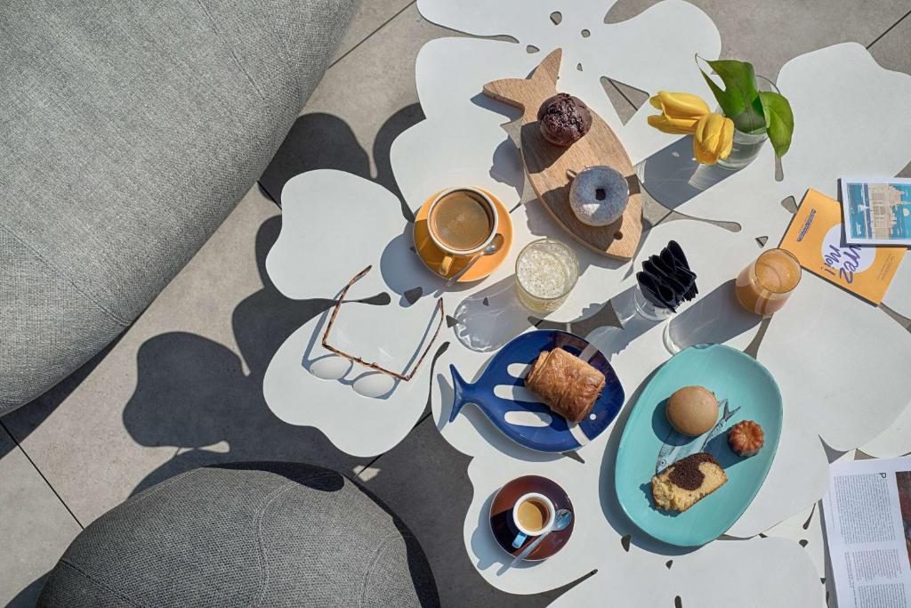 a table topped with plates of food and a cup of coffee at nhow Marseille in Marseille