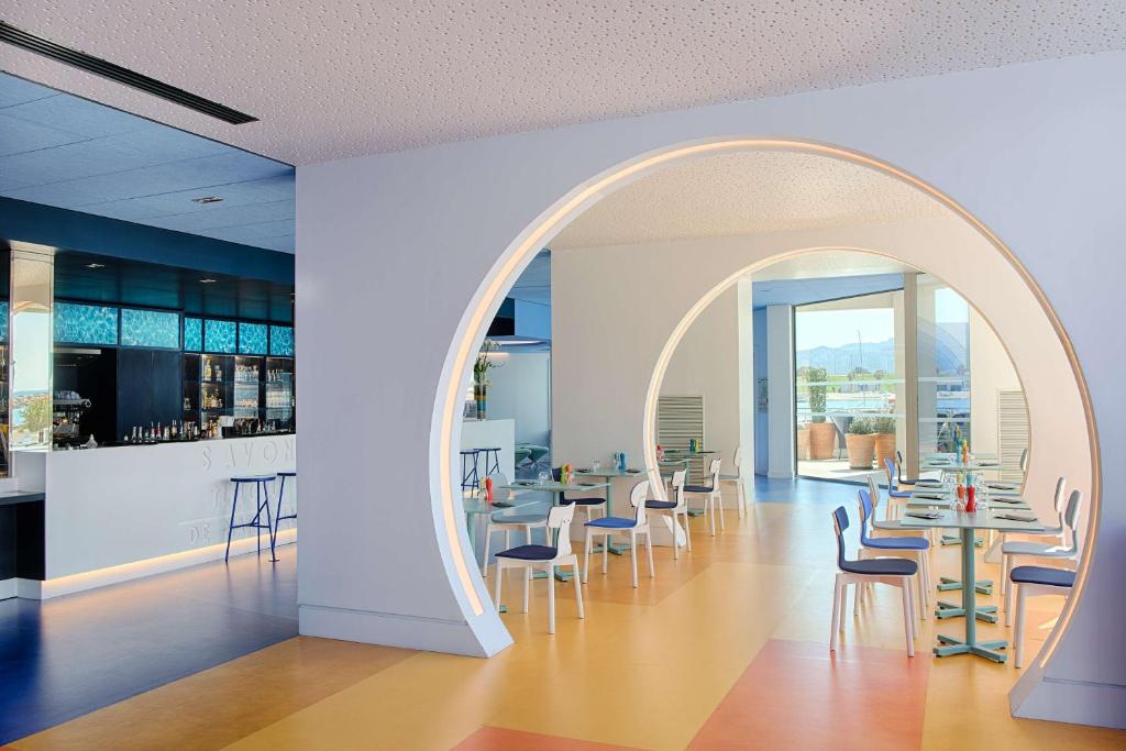 an archway in a dining room with tables and chairs at nhow Marseille in Marseille