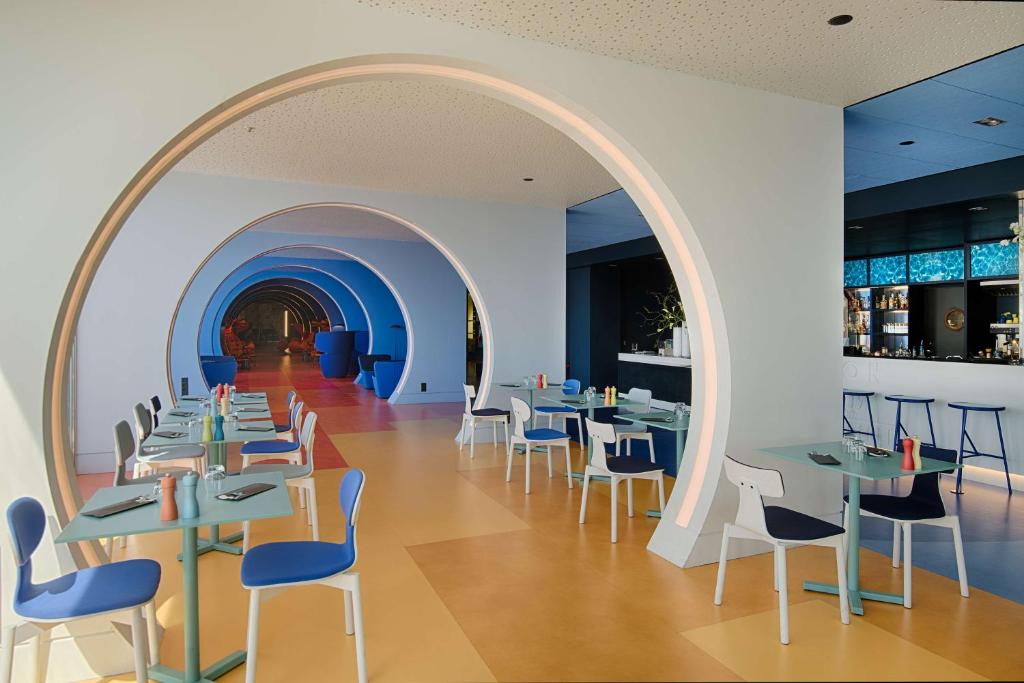 an archway in a restaurant with tables and chairs at nhow Marseille in Marseille