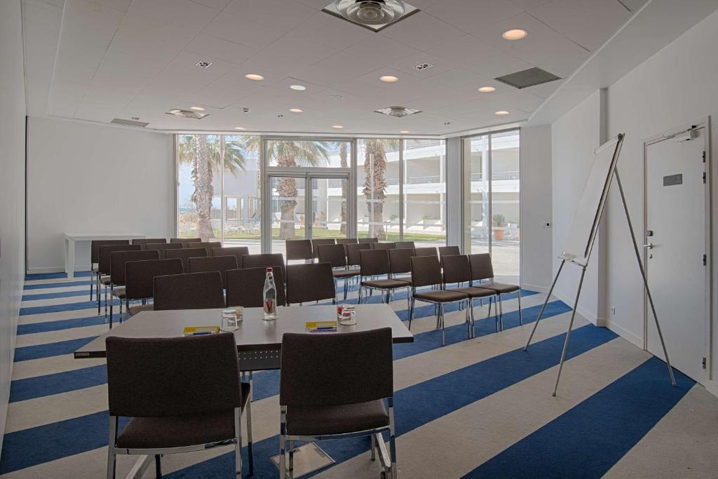 a conference room with tables and chairs and windows at nhow Marseille in Marseille