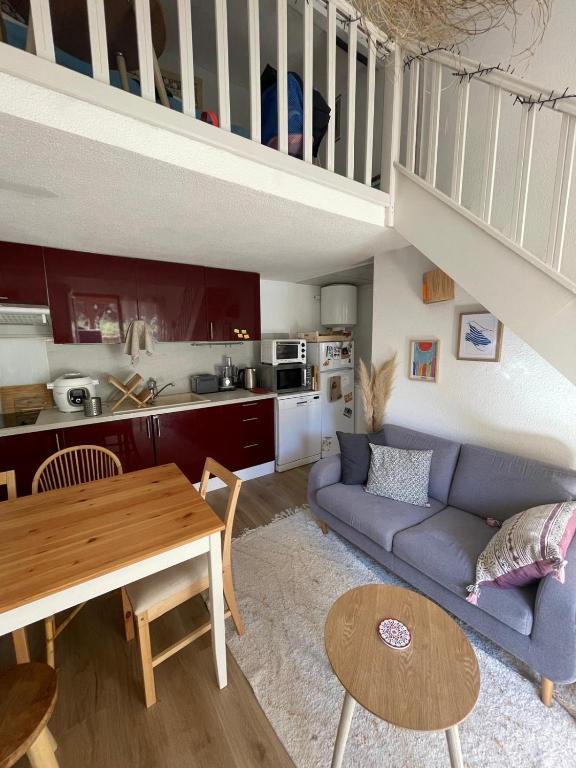 un salon avec un canapé bleu et une table dans l'établissement Maison de vacance bord de mer, au Barcarès